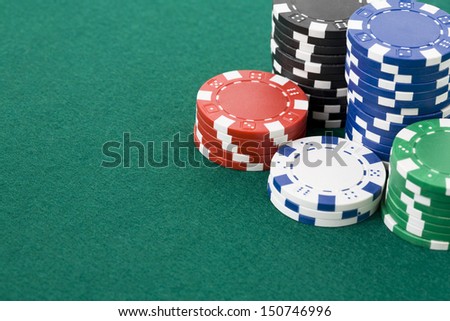Closeup of poker chips in stacks on green felt card table surface