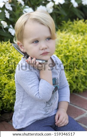 girl plays pretend with a cell phone