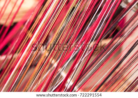 red thread from weaving machine traditional craft , Abstract background
