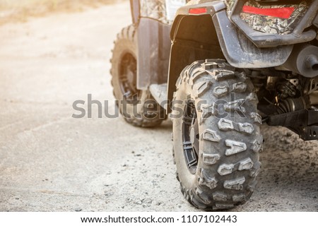 Close-up tail view of ATV quad bike. Dirty whell of AWD all-terrain vehicle. Travel and adventure concept.Copyspace.Toned