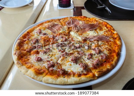 Thin-crust pizza with pork and ham.