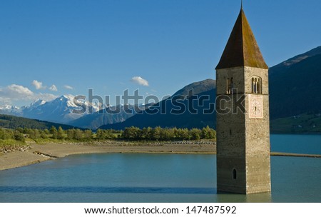 Italy South-Tyrol Reschen-reservoir gray steeple. Lake Reschen is an artificial lake located in the western portion of South Tyrol, Italy, near the Reschen Pass.