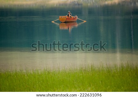 CRNE JEZORO ZABIJAK, MONTENEGRO - CIRCA AUGUST,2011 - Man sitting on a boat with a mobile phone. Lake Crne Jezero near village Zabijak - Durmitor National Park