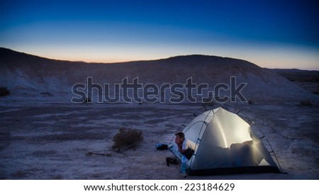 NEGEV DESERT, ISRAEL -  CIRCA MAY, 2013 - Hiker looking from tent, Negev Desert, Israel