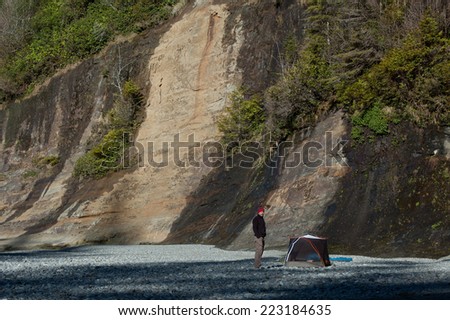 VANCOUVER ISLAND, CANADA -  CIRCA MAY, 2010 - Hiker standing near small tent, West Coast Trail, Canada