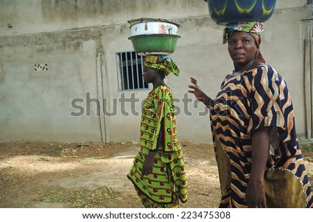 MAROUA,CAMEROON - CIRCA MAY 2008 -  Cameroonian woman in traditional dresses carrying their luggage on their heads , Maroua, Cameroon
