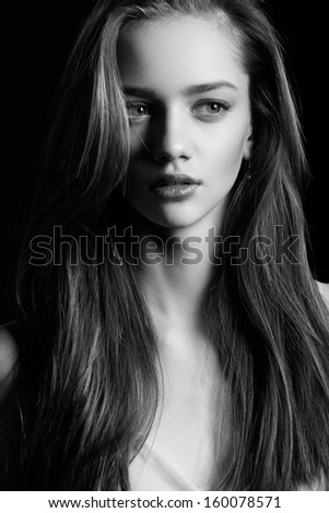 Young beautiful female with pretty long hair and natural make-up looking away. Black and White portrait