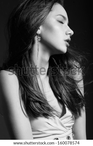 Profile of young beautiful female with pretty long hair, natural make-up and closed eyes. Black and White portrait