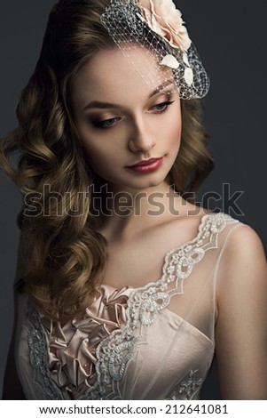 Young beautiful bride with long hair, bridal make up and a flower in her hair, looking down