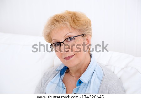 Portrait of an attractive elegant senior woman relaxing and dreaming at home