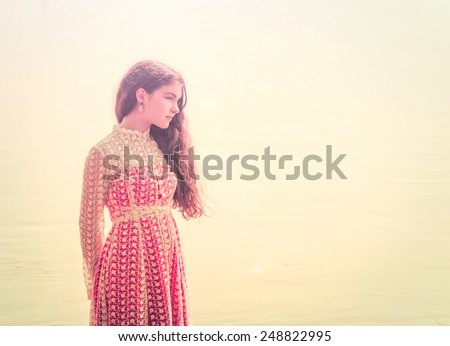 girl in long to a payment looks afar at the river