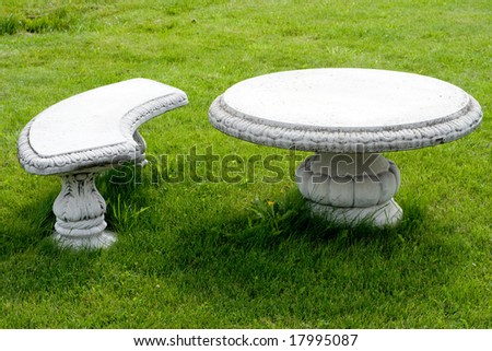 stone chair and table in green garden