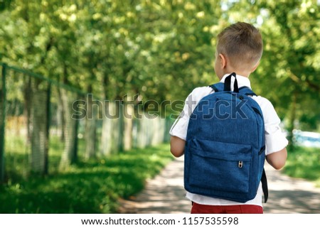 Back to school. A boy from an elementary school with a backpack on the street. The concept of the day of knowledge, September 1, the beginning of school.