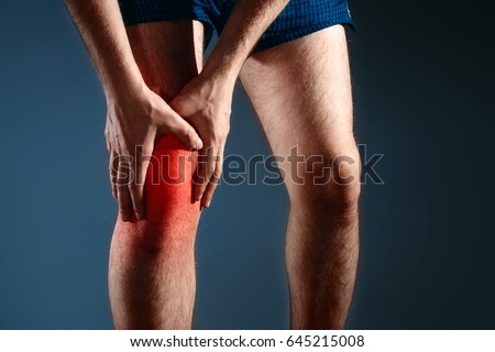 The man holds on to the knee, the pain in the knee