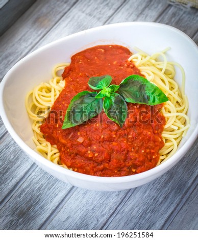 Spaghetti with marinara sauce and basil leaves on top