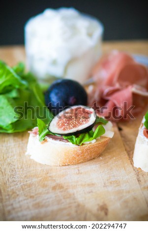 Crostini with figs, prosciutto, arugula and goat cheese