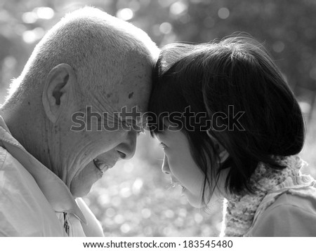 Portrait of grandfather and granddaughter, smiling at each other , BLACK AND WHITE , B&W