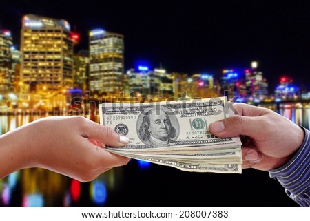 Human hands exchanging money on night city background
