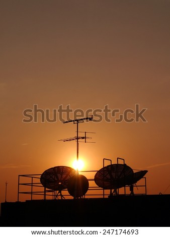 TV antenna , satellite dish silhouette on sunset background