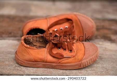 Old brown sneakers , Students sneakers on wooden background