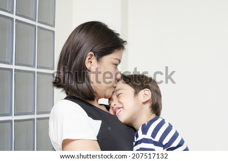 Mother is  kissing son