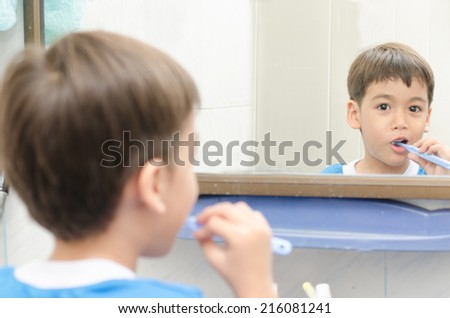 Little Boy brushing Teeth on white background