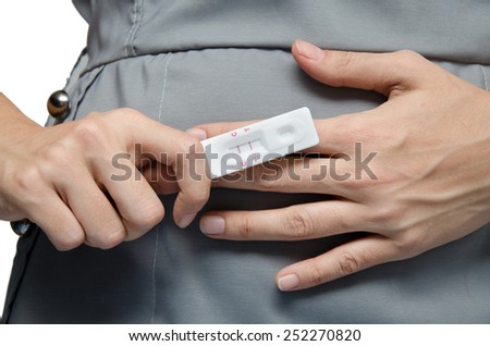 Woman holding positive pregnancy test with two red stripes