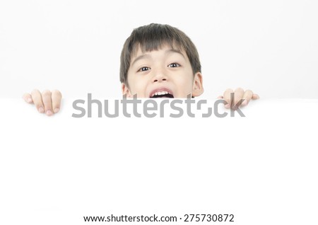 Little boy with surprise face behind the whiteboard
