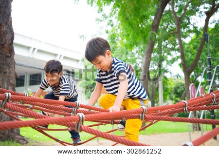 Little boy climbing rope at playground