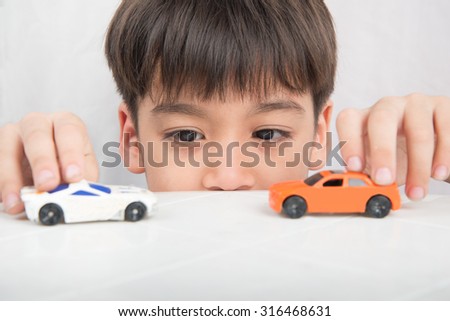 Little boy playing with car toy on  the table
