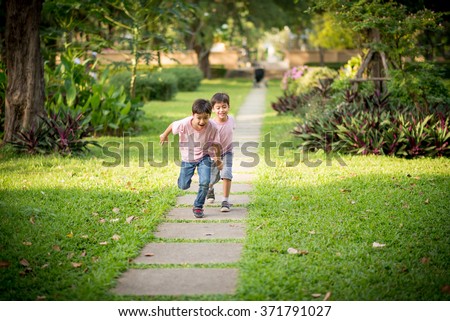 Little sibling boy playing together in the park