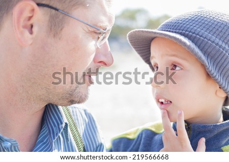 son father look each other talk closeup outdoor