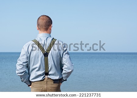 man 40 years standing back looking sea