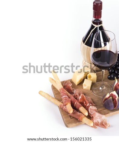 Bottle of red wine, glass and snacks on white background