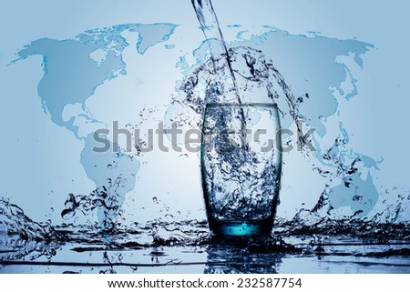 Water flowing and splashing into a glass with water world map