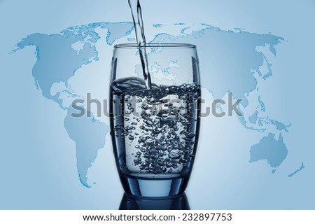 Water flowing and splashing into a glass with world map