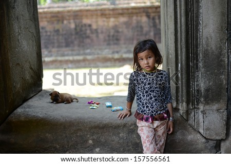 Angkor wat temple, Siem Reap, Cambodia - April 01, 2013 : A taciturn girl with puppy playing in the temple.