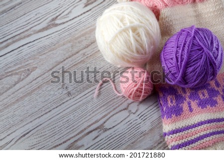 Ball of yarn and knitting on a wooden table