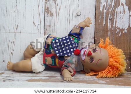 Sad old vintage doll on wooden background