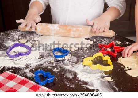 child rolls the dough for biscuits