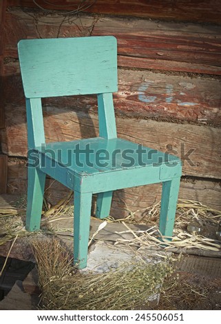old green chair against a wooden wall