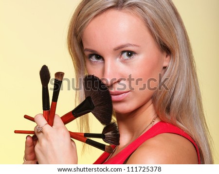 Portrait of a young woman with long hair on yellow background making beauty face and hair style. Smile happy girl with make up