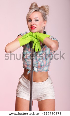 Cheerful pin up girl retro style portrait pinup Woman housewife cleaner mop pink background