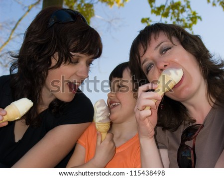 Two women and little girl eating ice-cream - vanilla ice cream. Outdoor