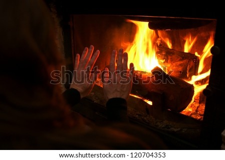 Woman  warm up by the fire / fireplace