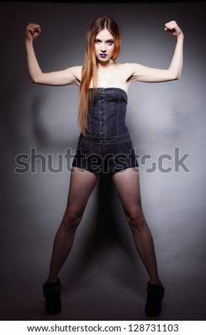 Full length woman long hair make-up posing in studio dark background strength and power concept