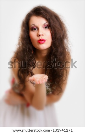 Beautiful young woman long curly hair  blowing a kiss  isolated on white background