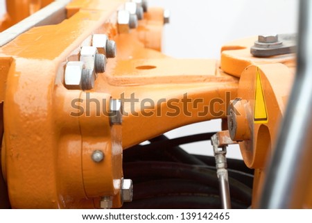 Screws and bolts on orange machine detail of industrial machinery