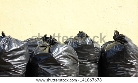 Pile of full black garbage bags outdoor