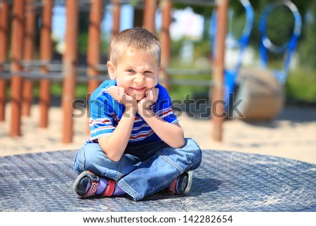 thoughtful child boy or kid in playground on leisure equipment